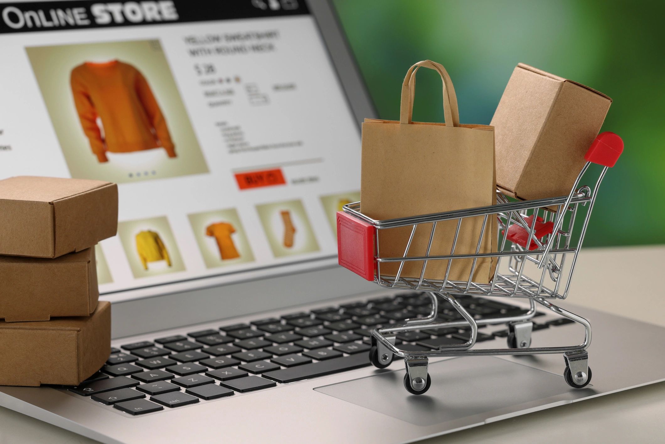 Ecommerce shopping cart and packages on a laptop representing online store development