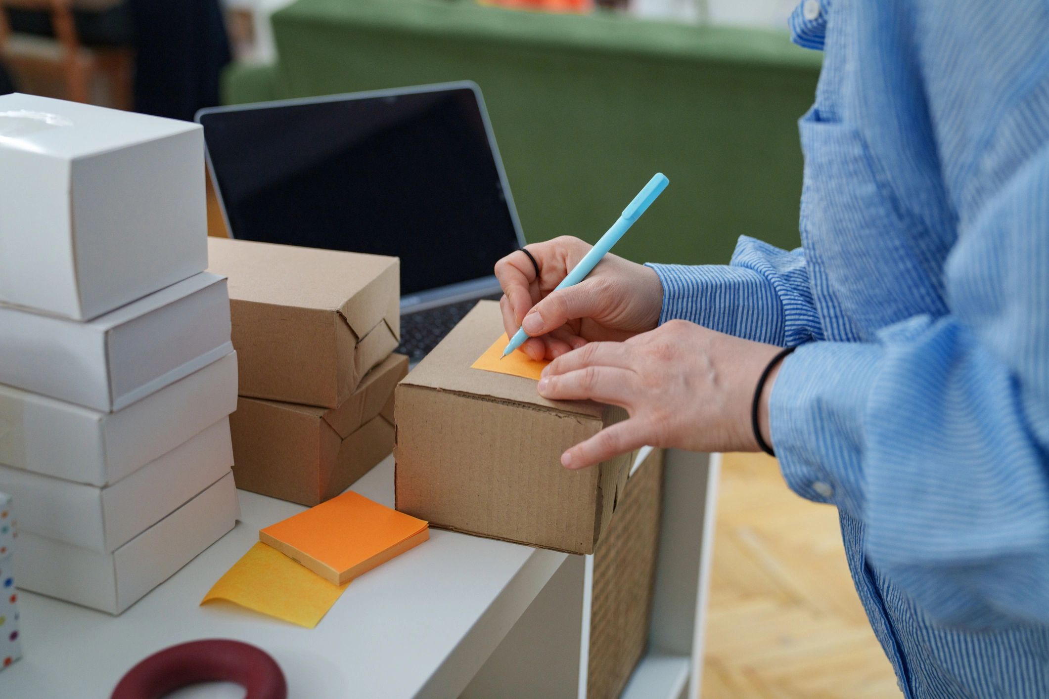 Small business owner writing on a shipping box