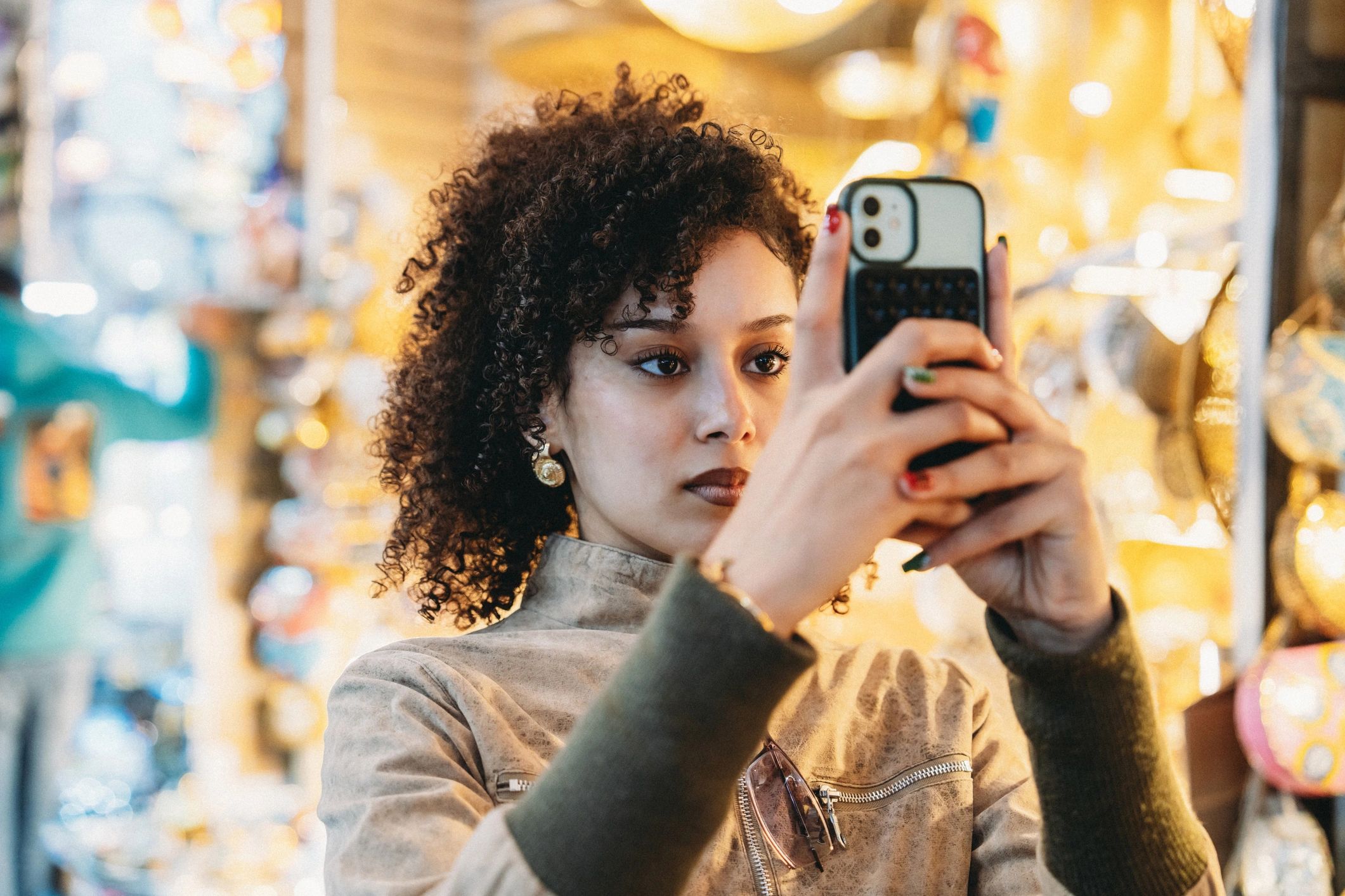Person filming a market scene with a smartphone
